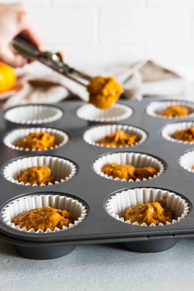Filling the muffin tins with muffin batter