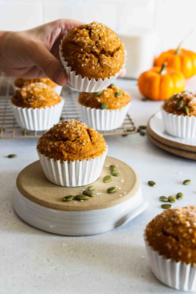 Vegan Pumpkin Muffins served on a white plate with more muffins in the background