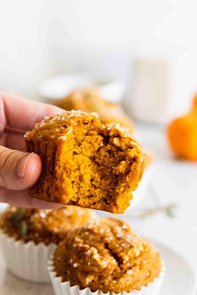 Vegan pumpkin muffins with a bite taking out of it