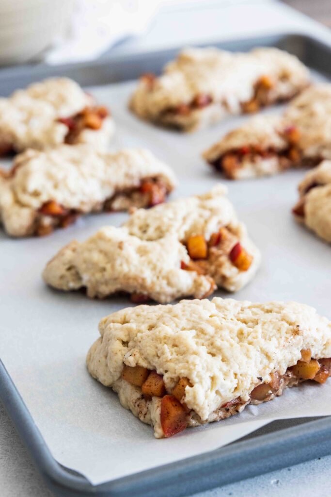 Apple scones on a baking sheet tray before baking