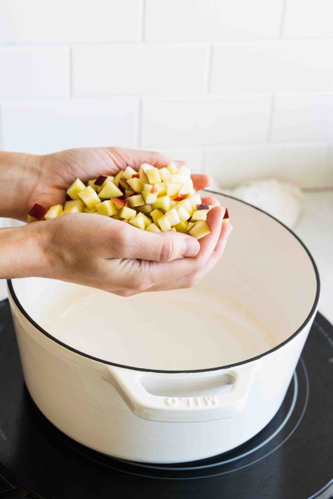 Adding chopped apples to a pot