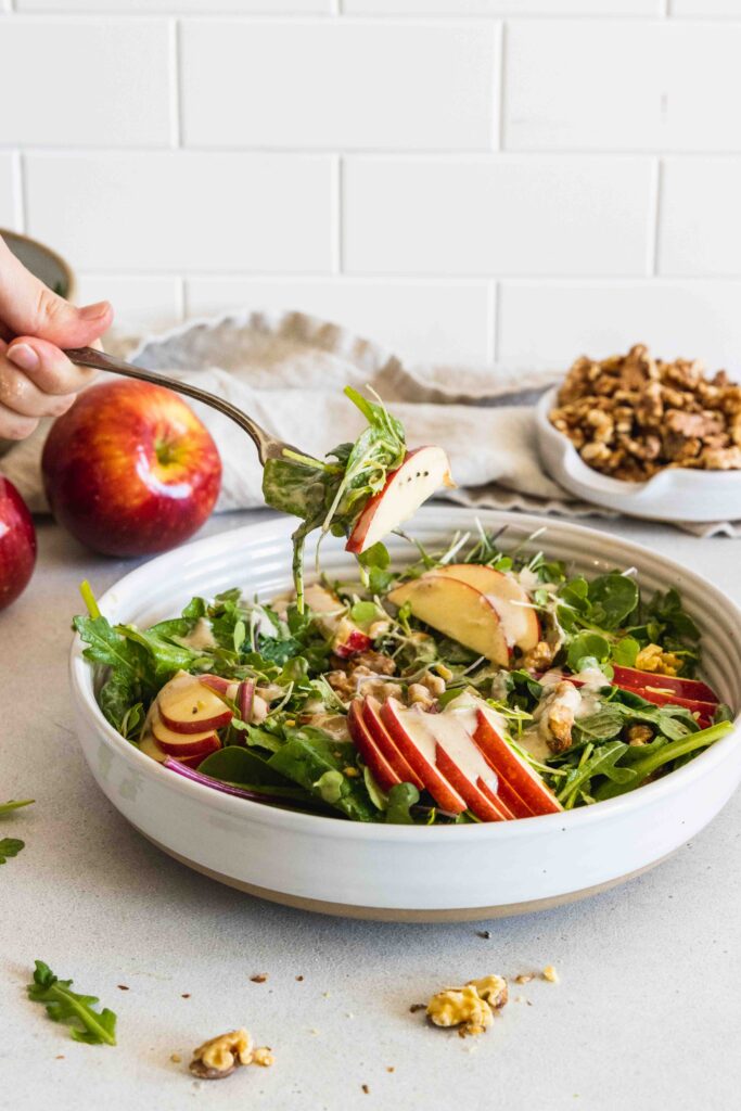 A fork full of apple walnut salad