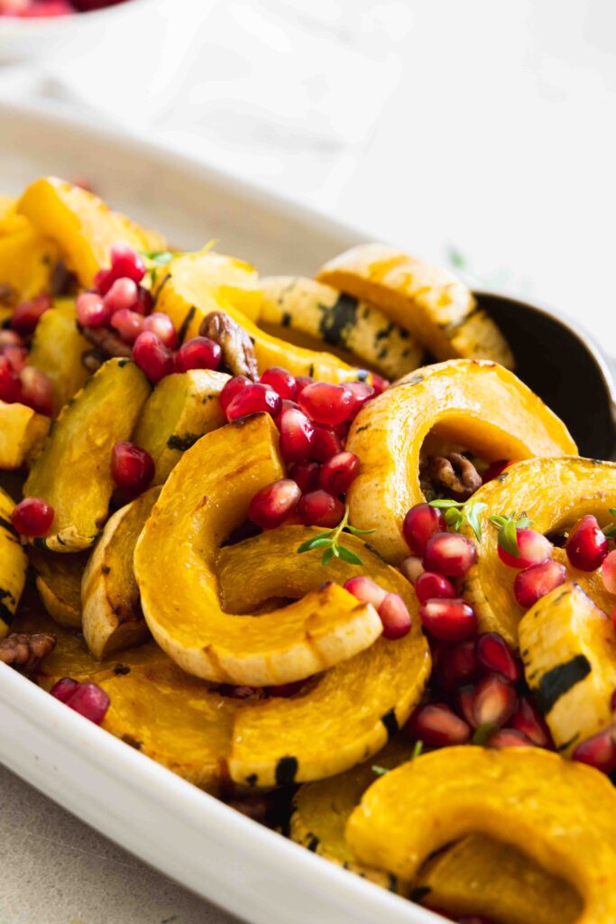 Roasted delicata squash served on a white serving plate