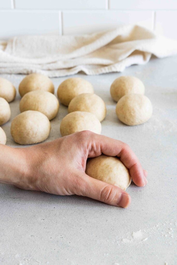 Showing how to roll the dinner rolls with the cupping hand technique