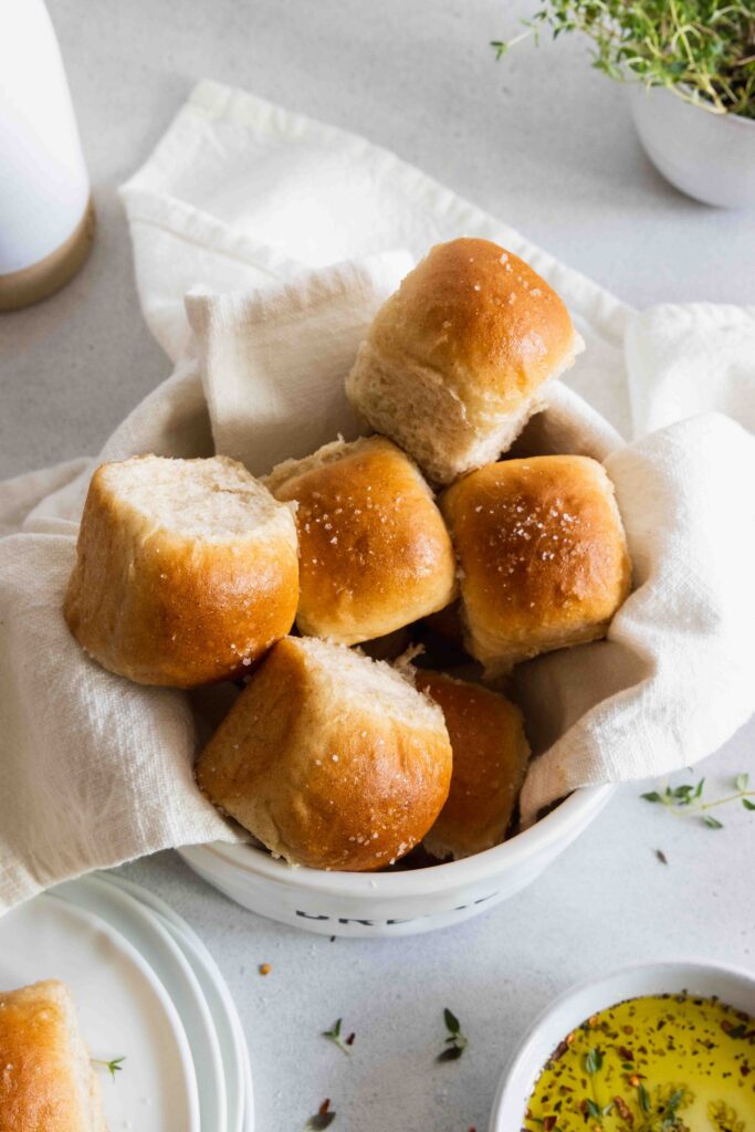 Vegan dinner rolls served in a bowl with a kitchen towel