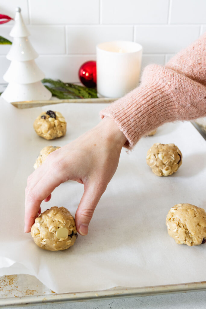Shaping the cookie dough balls and placing on a baking sheet