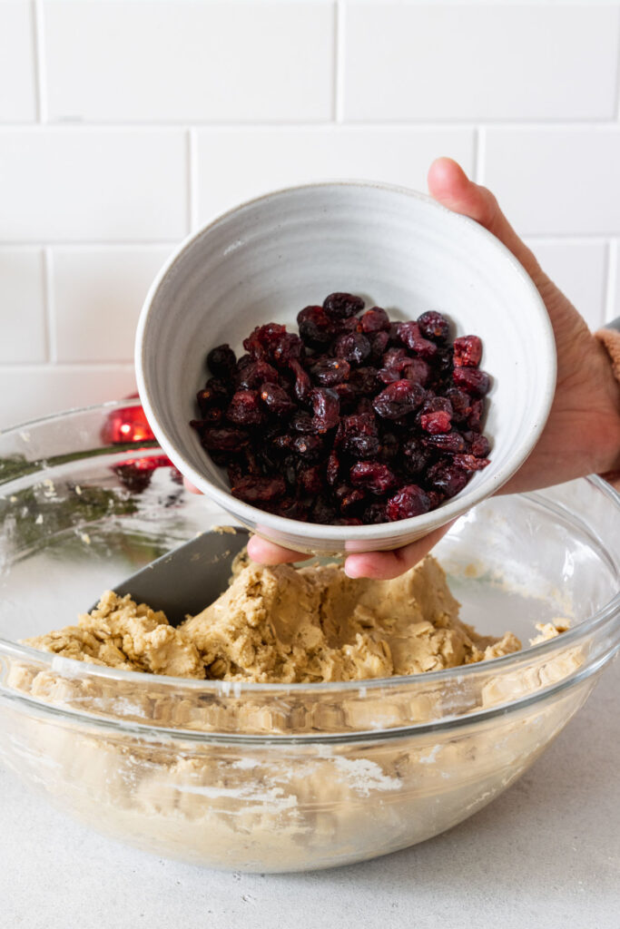 Adding dried cranberries to the cookie dough