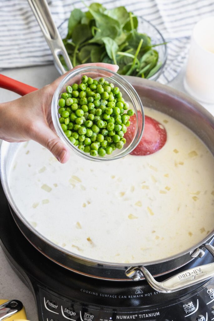 Adding frozen peas to the cream sauce