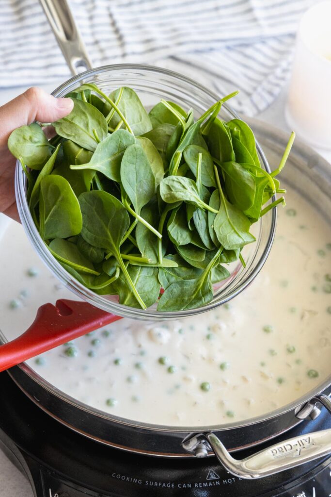 Adding fresh spinach to the sauce