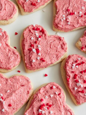 Soft frosted sugar cookies with vegan strawberry frosting served on a plate