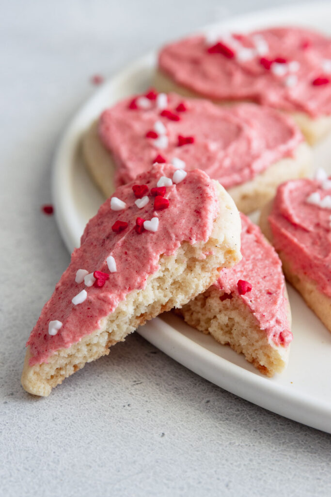 Soft frosted sugar cookie broken in half to show inside texture of cookie