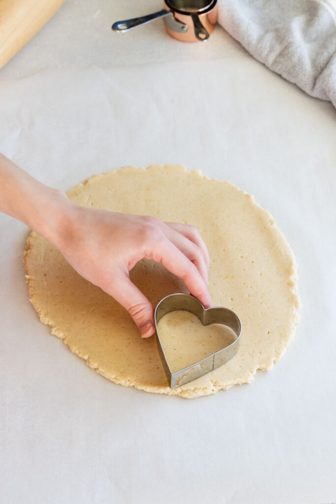 Cutting the heart cookies out with cookie cutters