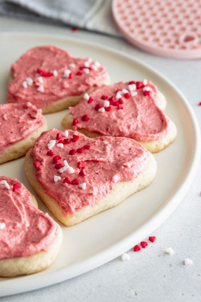 Vegan cookies with strawberry frosting served on a white plate