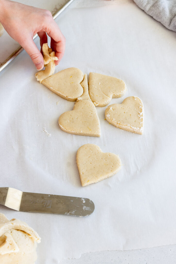 Removing the excess dough before transferring the cookies to a baking sheet tray