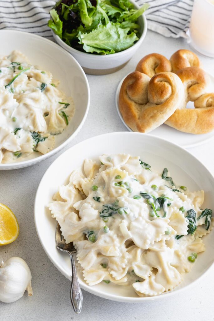 Pasta with vegan cream sauce served with fresh rolls